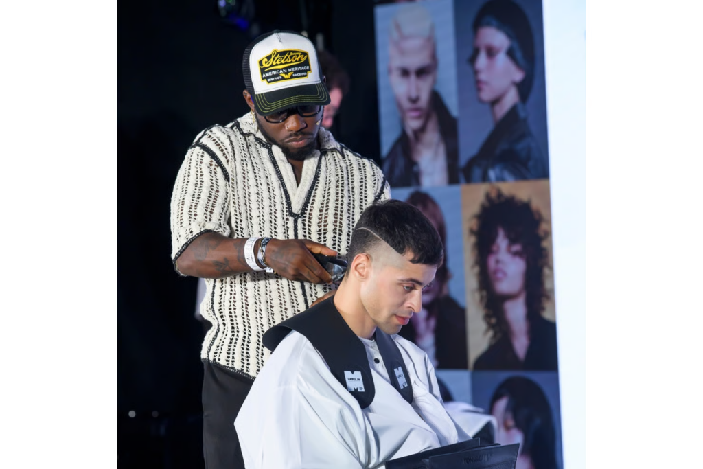 Stylist performing a live haircut demonstration on stage at Salon International