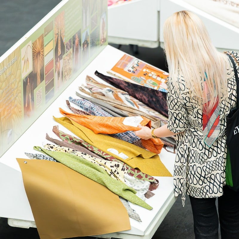 A buyer browsing fabric samples at the London Textile Fair